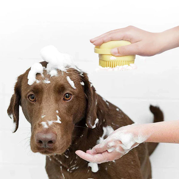 Silicone brush massaging a dog with soap foam in the bathroom.